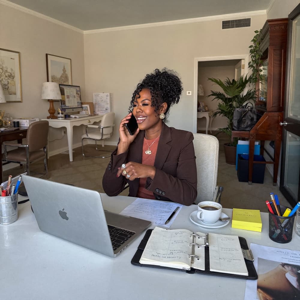 Zuleema at her desk with a laptop and planner, working through her day